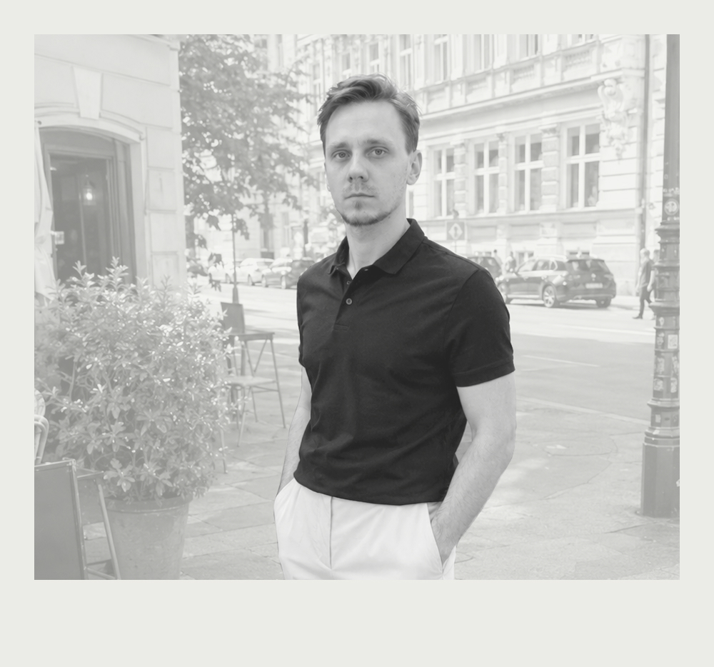 Black-and-white portrait of Andrii Naichuk standing on a city street