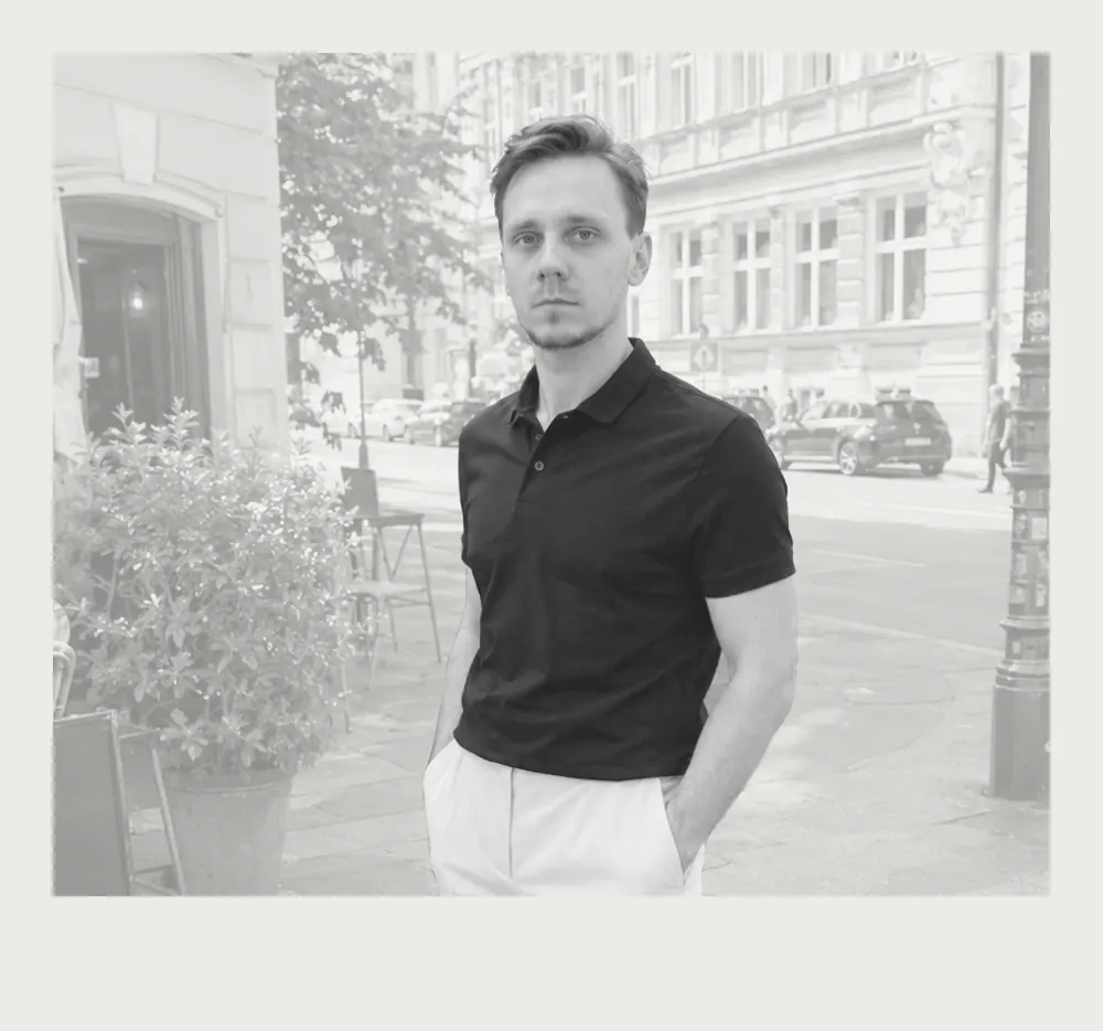 Black-and-white portrait of Andrii Naichuk standing on a city street